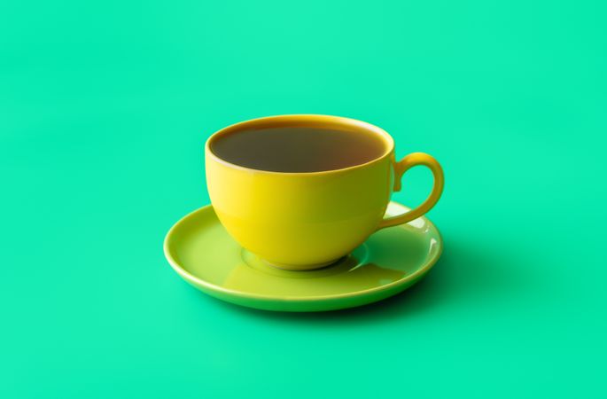 Mint tea in a yellow cup isolated on a green background