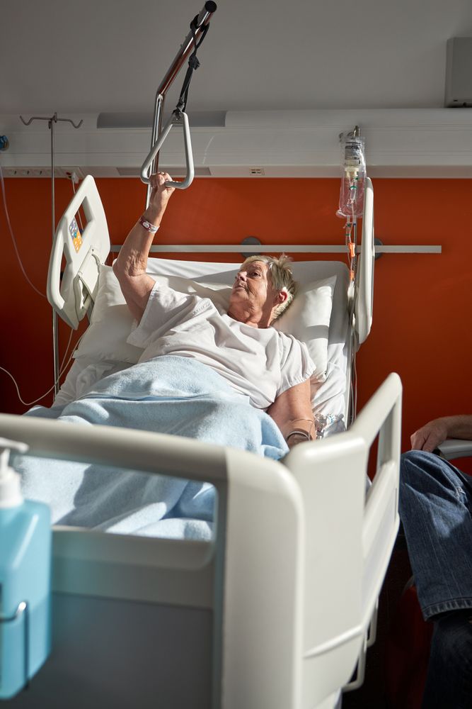 Older unwell woman lying on medical bed in hospital