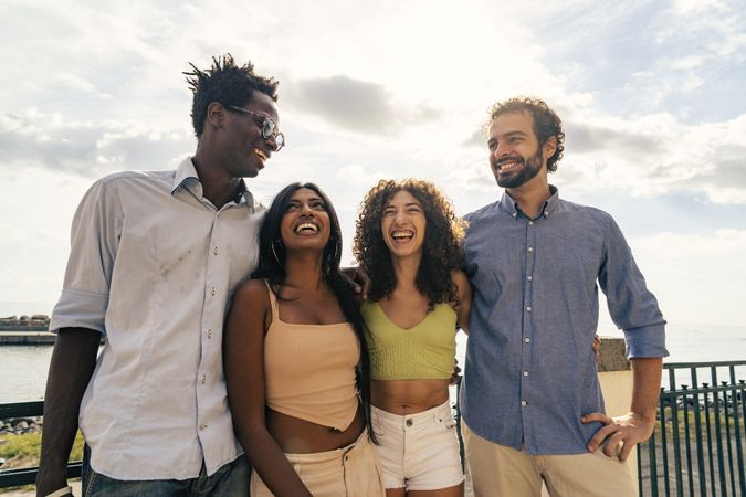 Group of happy friends laughing together by the sea