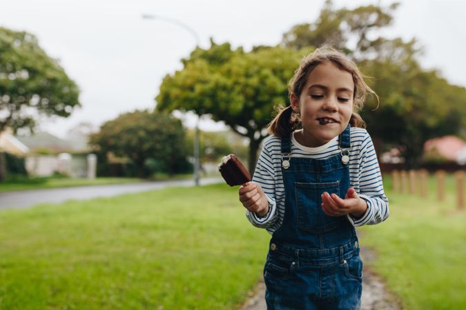 Portrait of cute little girl eating ice cream outdoors