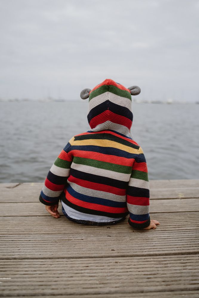 Anonymous kid sitting on pier