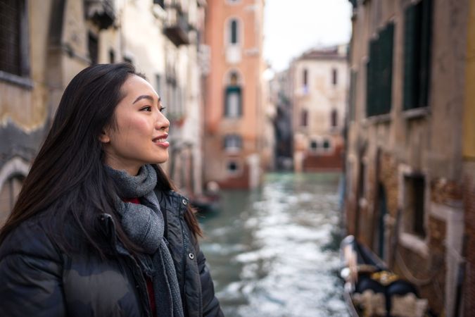 Satisfied Asian resting woman exploring old city with waterways