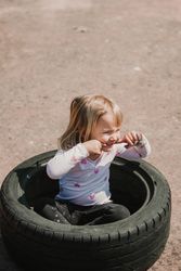 Little girl sitting inside tire
