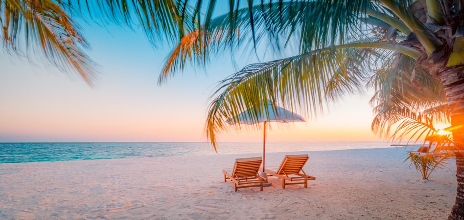 Tranquil beach at sunset with relaxing beach chairs