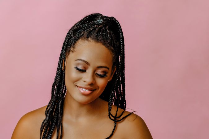 Shy female looking down in pink studio shoot