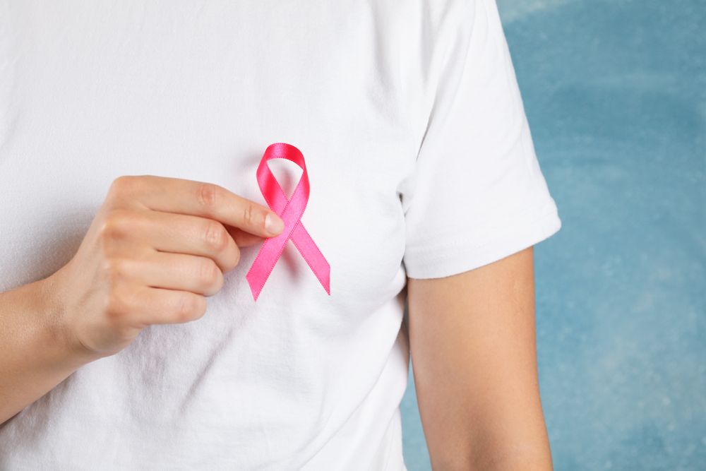 Person in t-shirt hold awareness ribbon against blue background