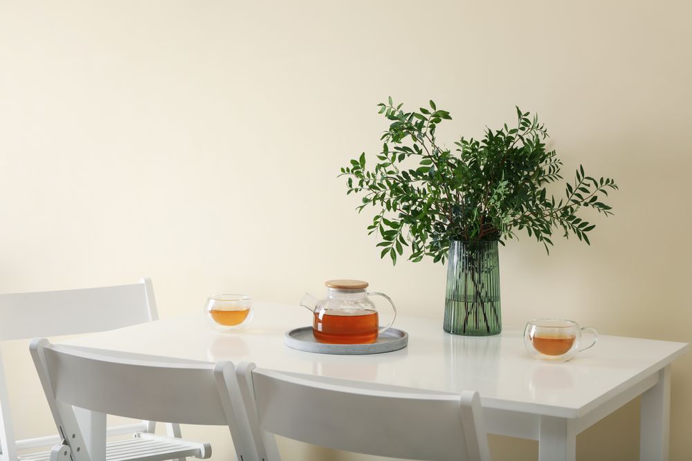 kitchen table with tea and plant in bright room