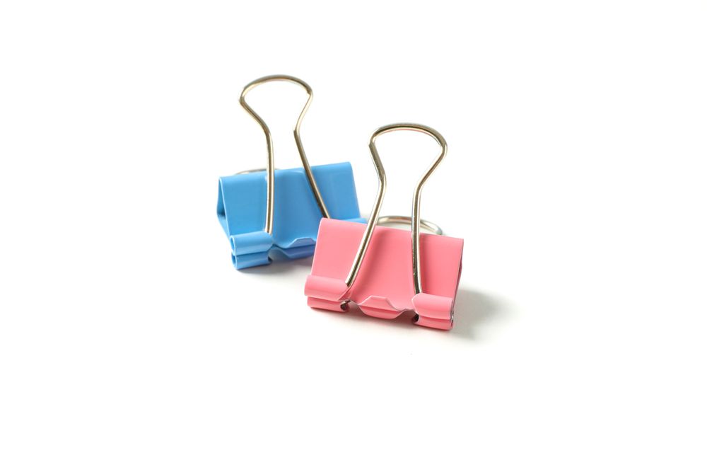 Color paper clips isolated on studio background