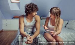Young couple with pregnancy test having a discussion 0gX7Wj