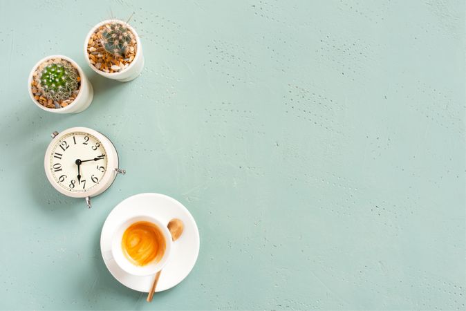 Espresso with succulents and clock on baby blue background