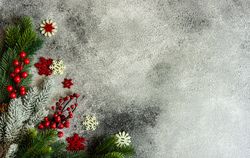 Christmas frame with pine and snowflake ornaments on stone background