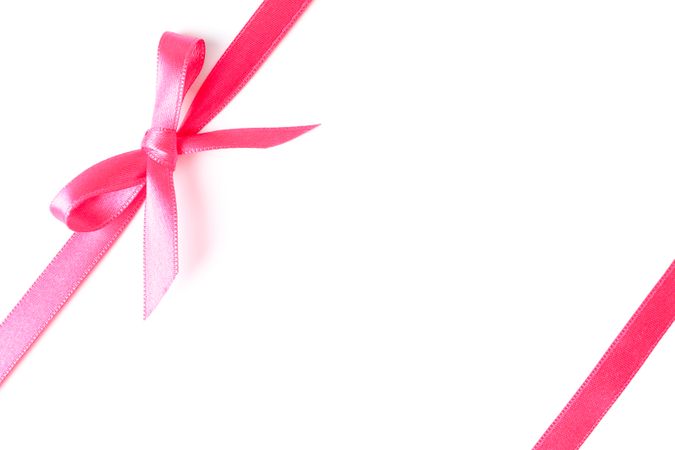 Pink ribbons with bow isolated on plain background. Gift concept