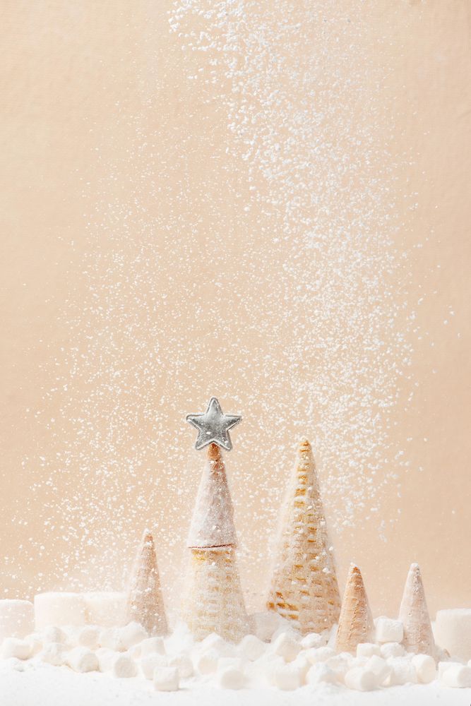 Christmas or New Year background with Christmas tree of waffle cones and falling sugar snow