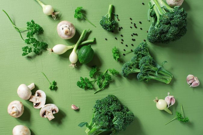 Top view of fresh vegetables on textured green tablecloth