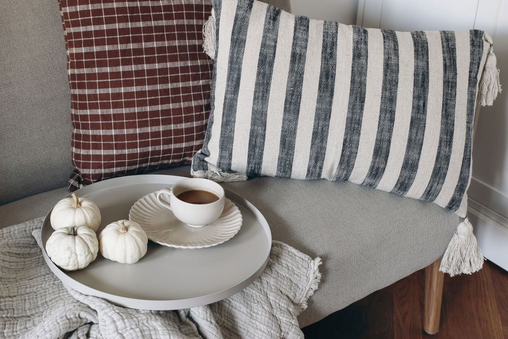 Still life decorative details at home with cup of coffee, round serving tray, little pumpkins