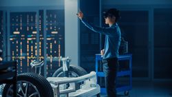 Automotive Engineer Working on Electric Car Chassis Platform, Using Augmented Reality Headset with Touching Gestures.