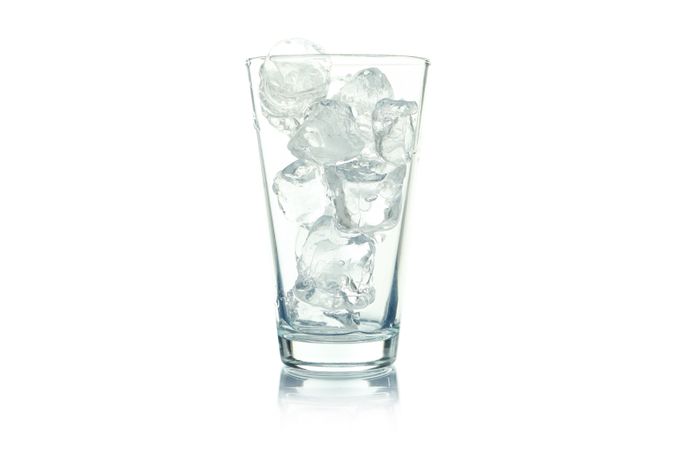 Tall glass full of ice on blank background