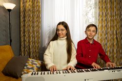 Two children playing digital piano together