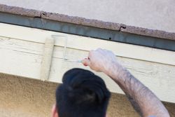 Professional Painter Using Small Roller to Paint House Fascia