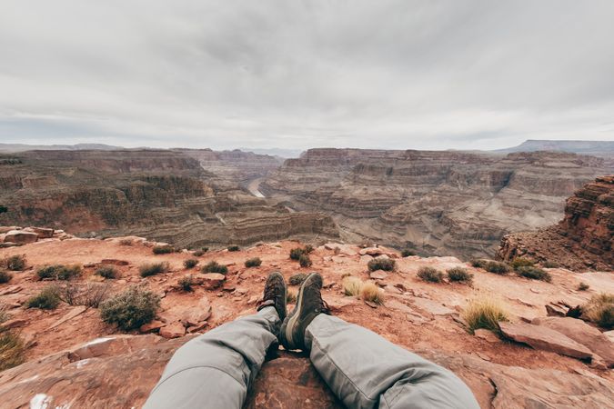 Exhausted male having break on deserted rock