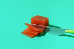 Slicing quince marmalade on a blue background