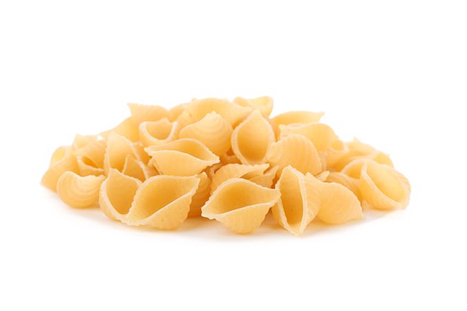 Pasta isolated on bright background, closeup. Dry uncooked whole pasta