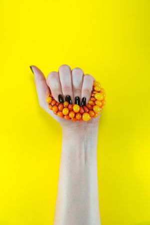 Person holding orange and yellow beads