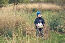 Positive boy with ball in nature