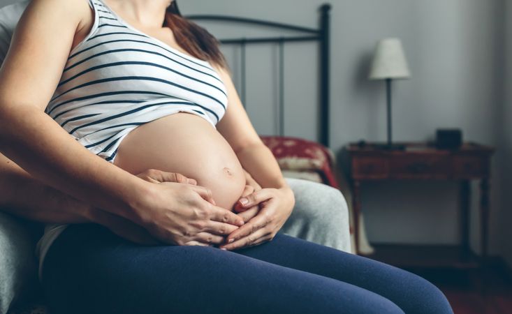 Pregnant woman embraced by her husband