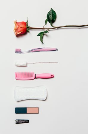 Feminine accessories in pink tones over plain background