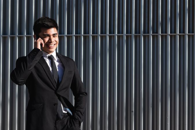 Smiling businessman speaking on smartphone in downtown