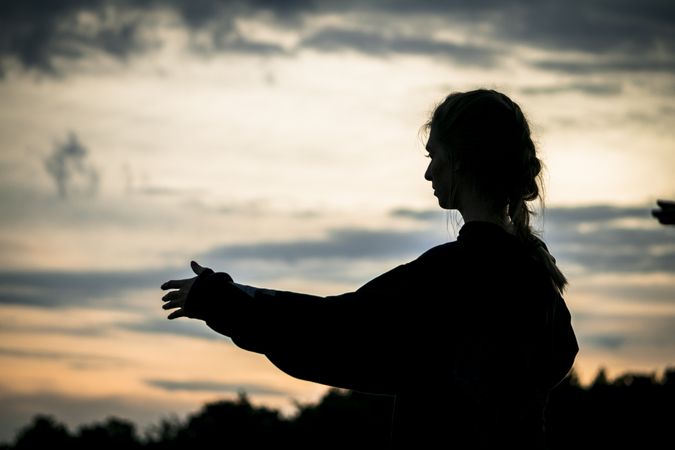 Woman meditating during sunset in nature