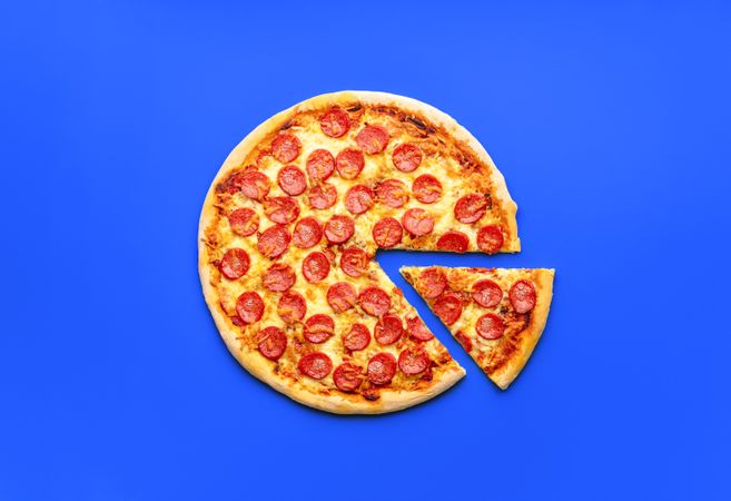 Homemade pepperoni pizza isolated on a blue background