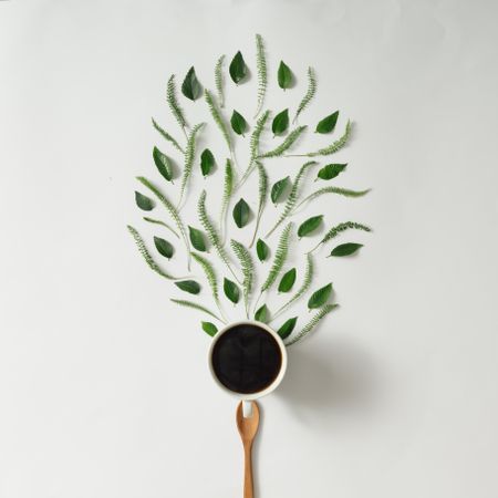 Coffee cup with leaves and wooden spoon
