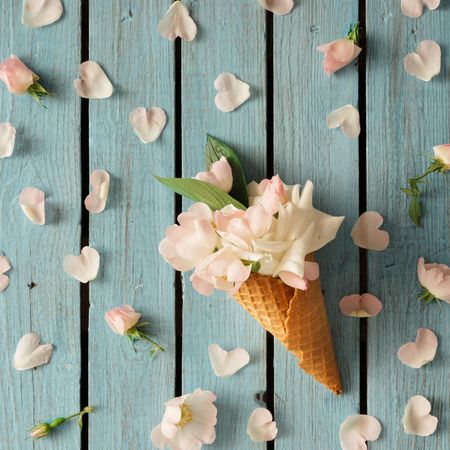 Flowers in ice cream cone on wooden background