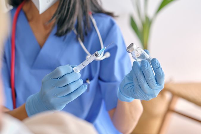 Crop physician with syringe and vaccine in house