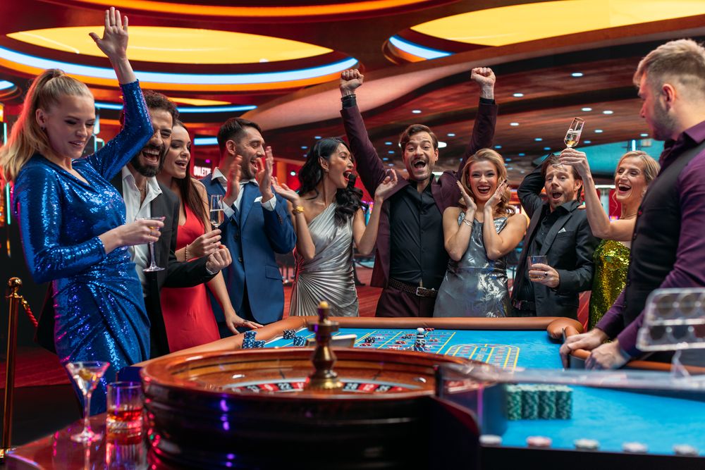 Croupier Focused on Table with Tokens, while Ball Spins on the Ball Track.