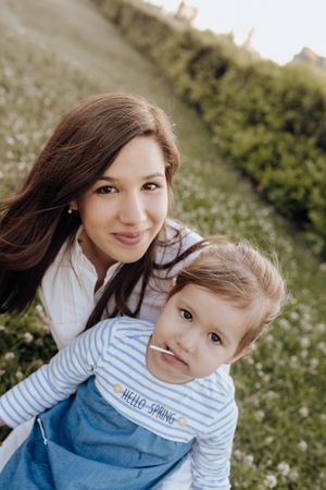 Mother and daughter sitting on lawn