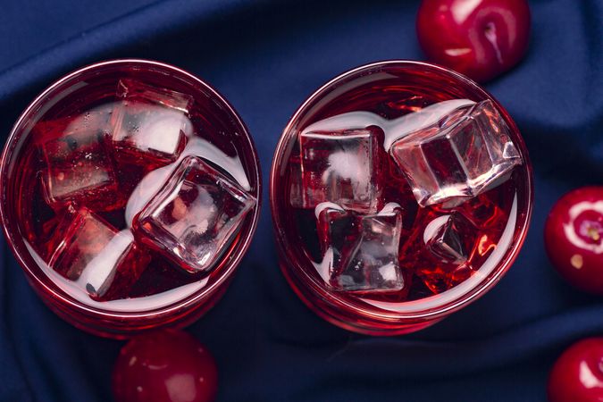 Red beverage near fresh fruits on cloth