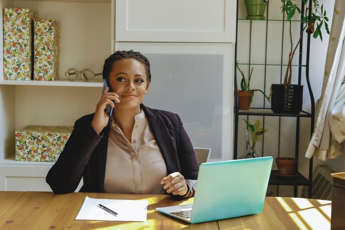 Female business owner concentrating on phone call in her home office