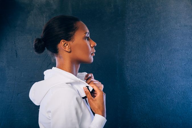 Woman in sports clothes with hood down, side view