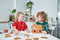 Content children making gingerbread house