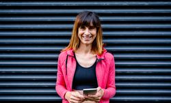 Happy female athlete with mobile phone