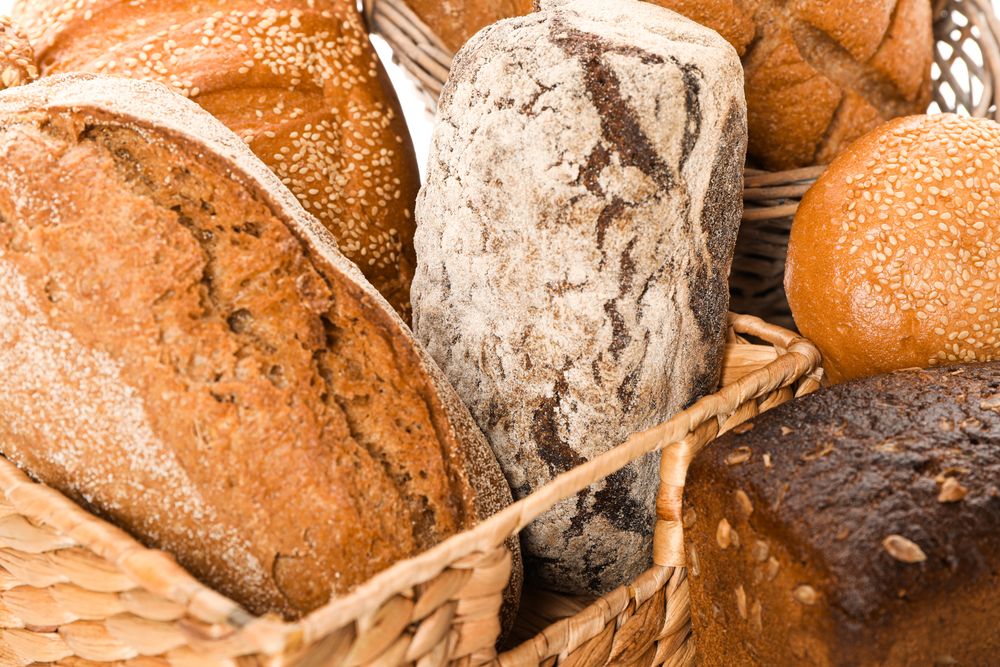 Bakery products in straw basket as background, closeup