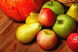 Wooden table with autumnal fruit and squash