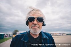 Man with gray hair and beard wearing sunglasses looking at camera 5aX2d0