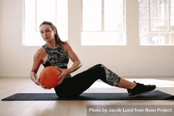 Side view of a fitness woman doing workout using medicine ball 0y2YW5