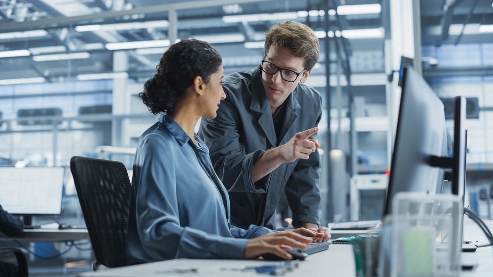White Man and Hispanic Woman Having a Conversation at Industrial Facility.