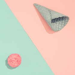 Ice cream cone with scoop of ice cream on pastel pink and blue background