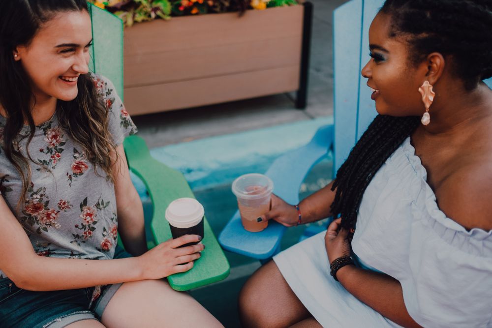Multiethnic modern women talking at coffee shop